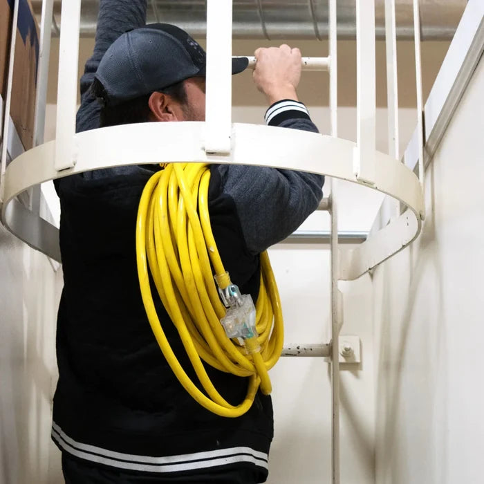 Worker Carrying The DuroMax 25-Foot 10 Gauge Triple Tap Extension Power Cord