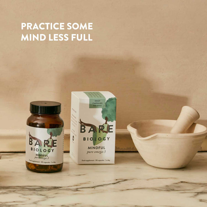 Bare Biology supplement bottle and box on a marble surface with a mortar and pestle.