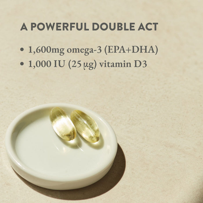 Two capsules on a white dish with text about omega-3 and vitamin D3 on a beige background